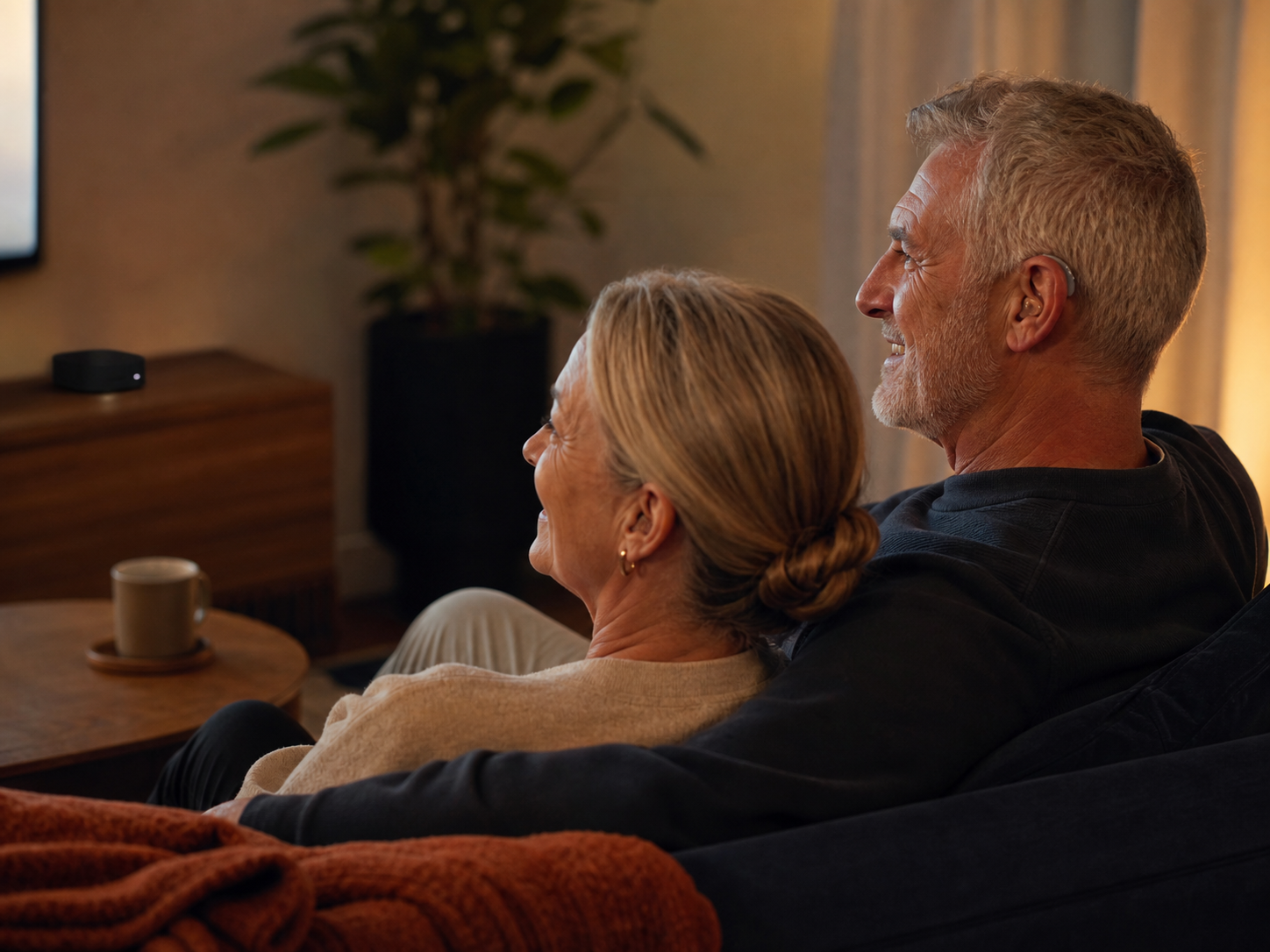 A couple enjoying television with a hearing aid TV streamer